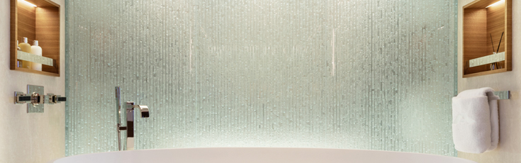 A glass wall in the MYS Atomic master bathroom